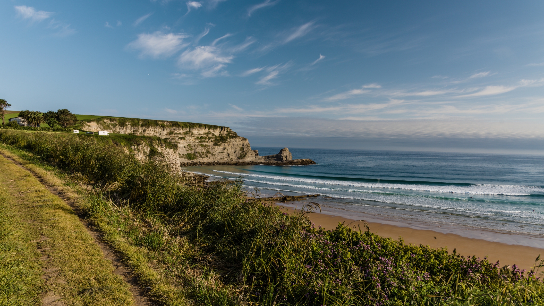 Coastal path above sandy beach and limestone cliffs, Camino del Norte