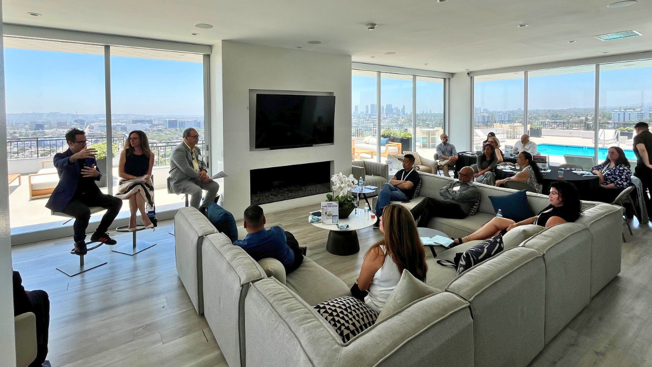 Sam Osborne leading a panel discussion overlooking the Los Angeles skyline